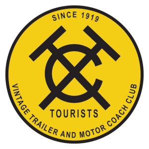 Logo of the Vintage Trailer and Motor Coach Club, featuring a circular design with a yellow background, black lettering, and graphic elements including the letters 'T', 'C', and 'H'. The text reads 'TOURISTS' and 'SINCE 1919'.